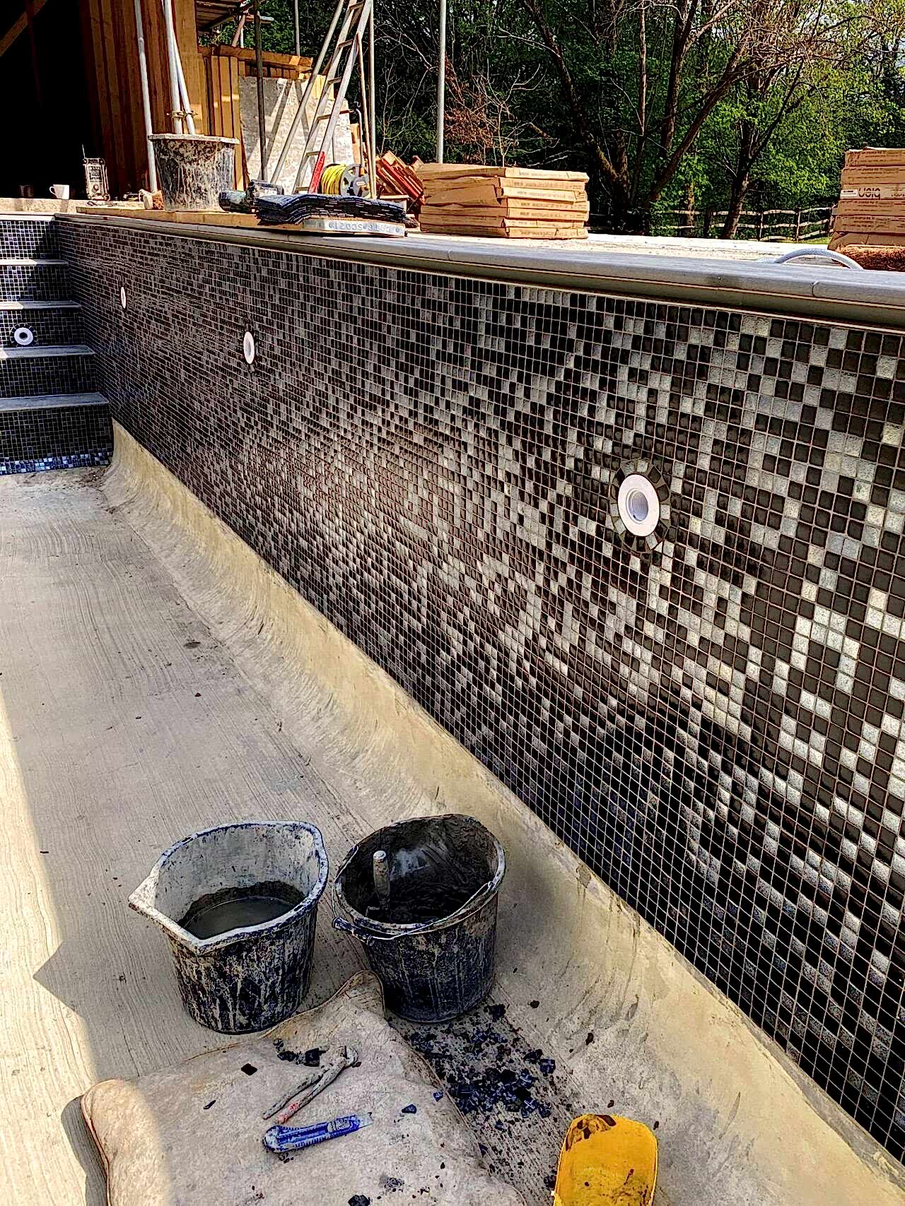 Close-up of the side of the swimming pool while the tiles being installed