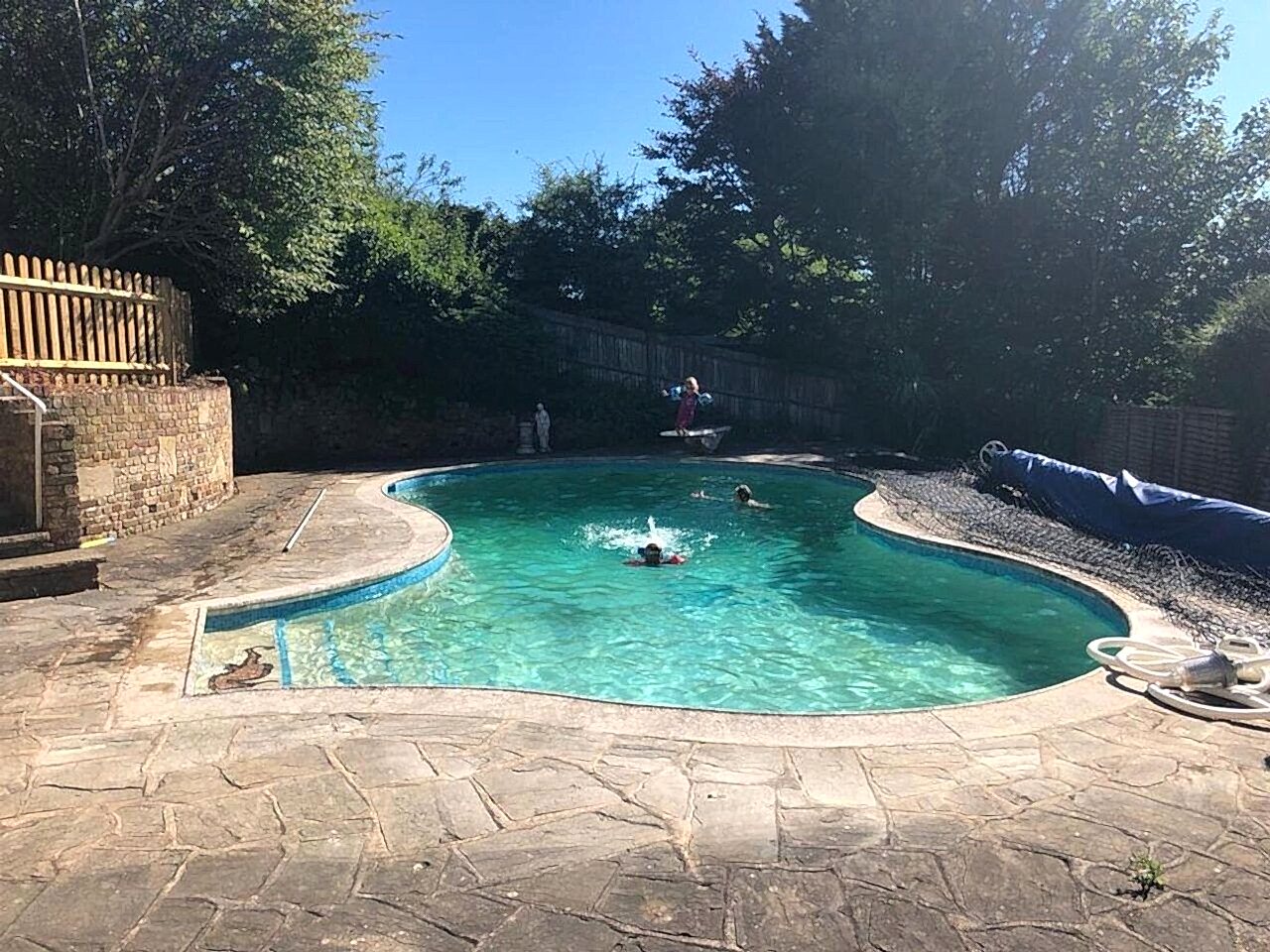 The original irregularly shaped residential swimming pool before the renovation