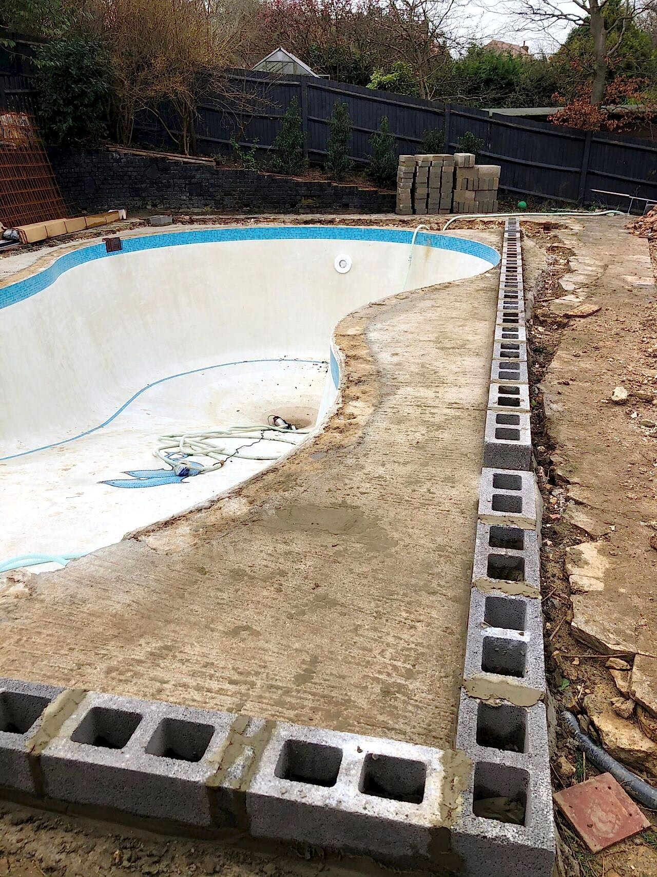 Concrete was applied around the pool for strength and stability