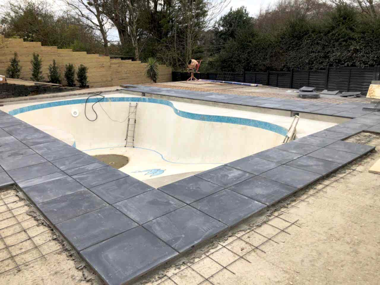 The original concrete pool was redesigned into a rectangular shape with integrated beach entries on two sides to facilitate supervised child access