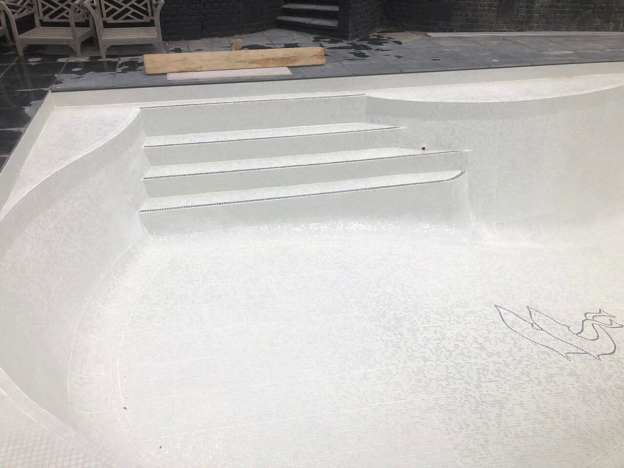 The entire pool interior was retiled with contemporary white glass mosaics and contrasting step demarcations