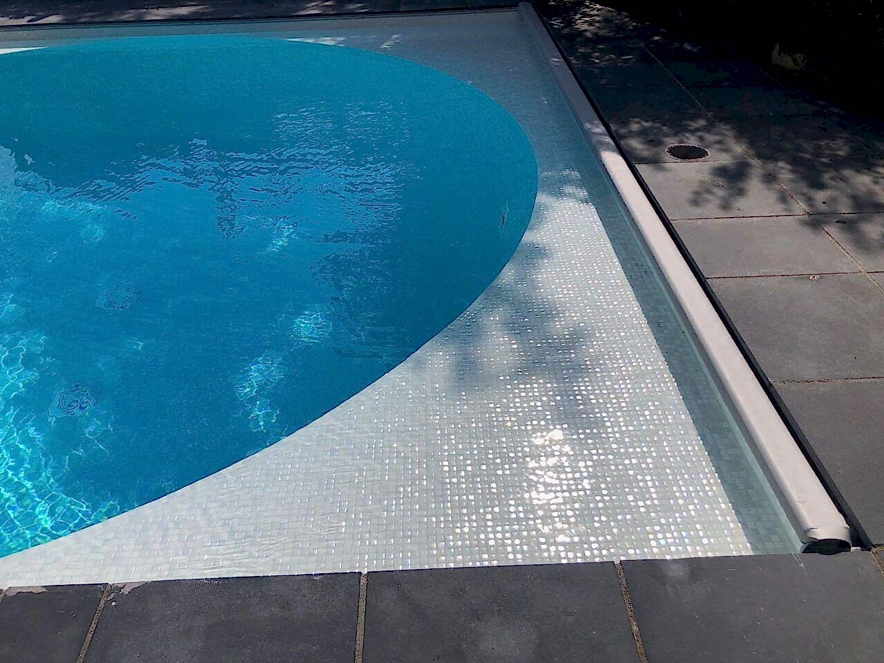 Close-up of the edge of the new swimming pool showing the automated cover location