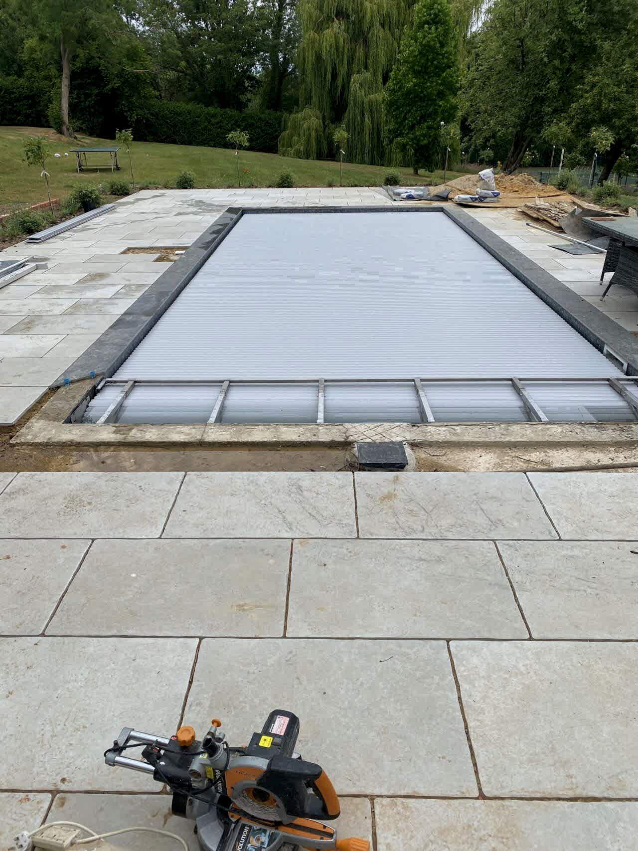 A seamlessly integrated in-ground slatted automatic cover system in the new pool design