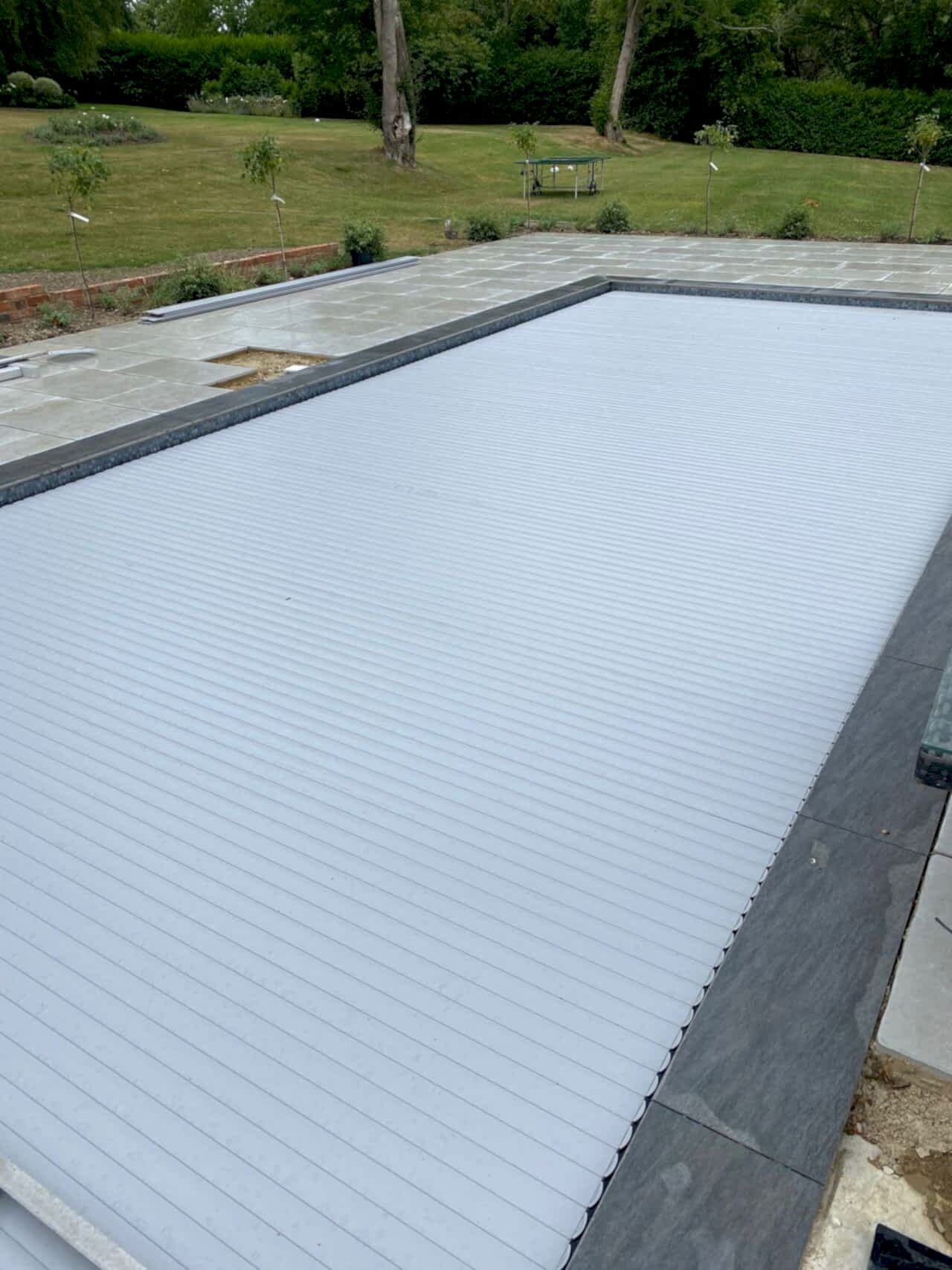 The pool, covered with the in-ground slatted automatic cover system