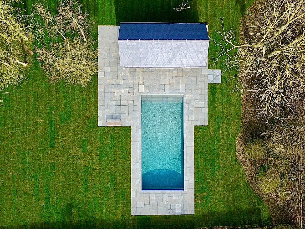 Luxury swimming pool with a pool house by UK Swimming Pools Ltd