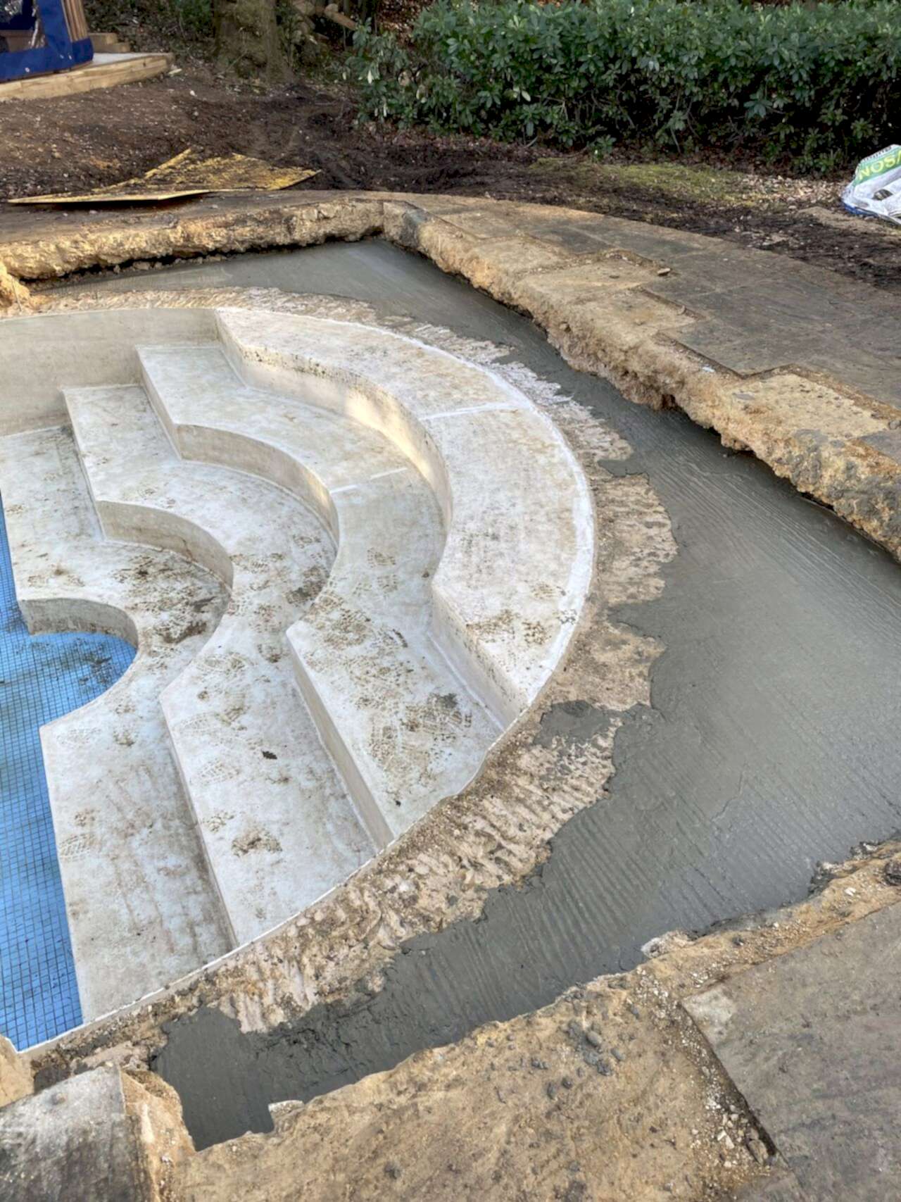 Concrete poured over reinforced mesh to strengthen the swimming pool structure