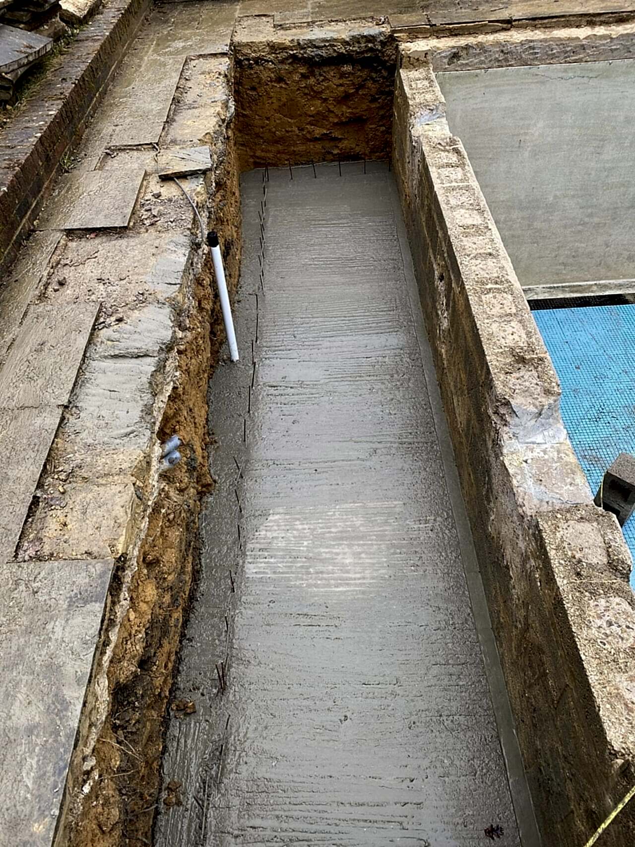 Concrete poured over reinforced mesh to strengthen the chamber for the automatic swimming pool safety cover