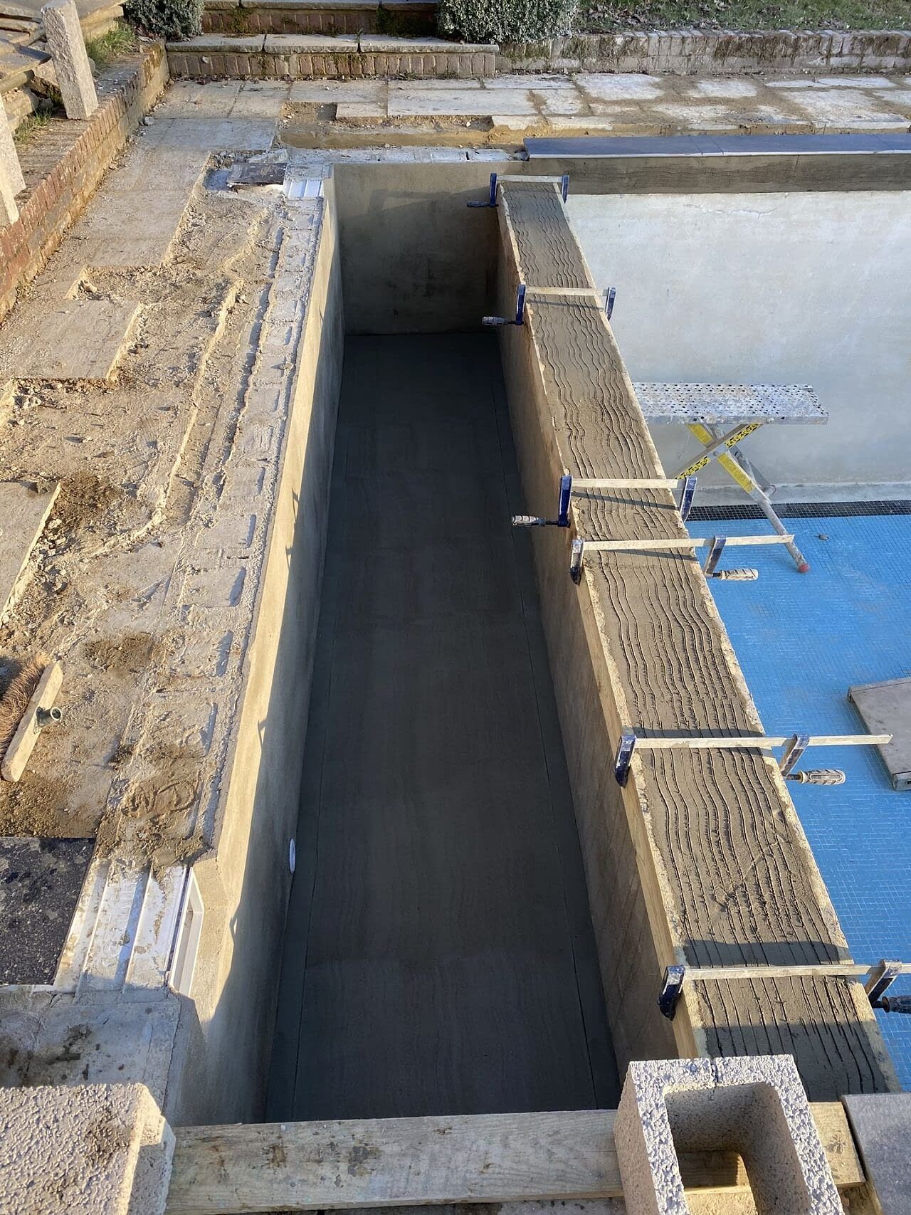 Concreted chamber constructed ready for the installation of an automated slatted swimming pool safety cover