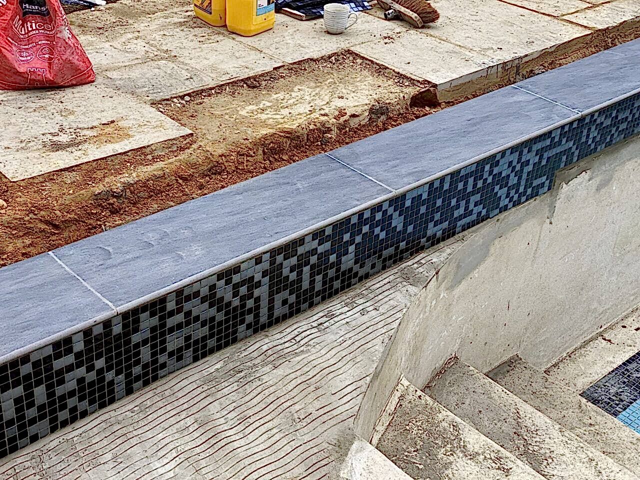 Close up of the new mosaic tiled band to the refurbished swimming pool