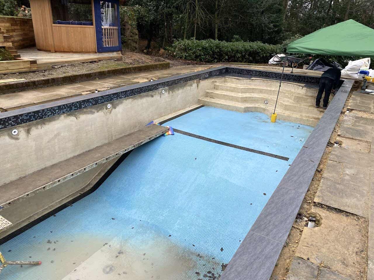 Mosaic tile band installation around the newly built transitional “beached” areas