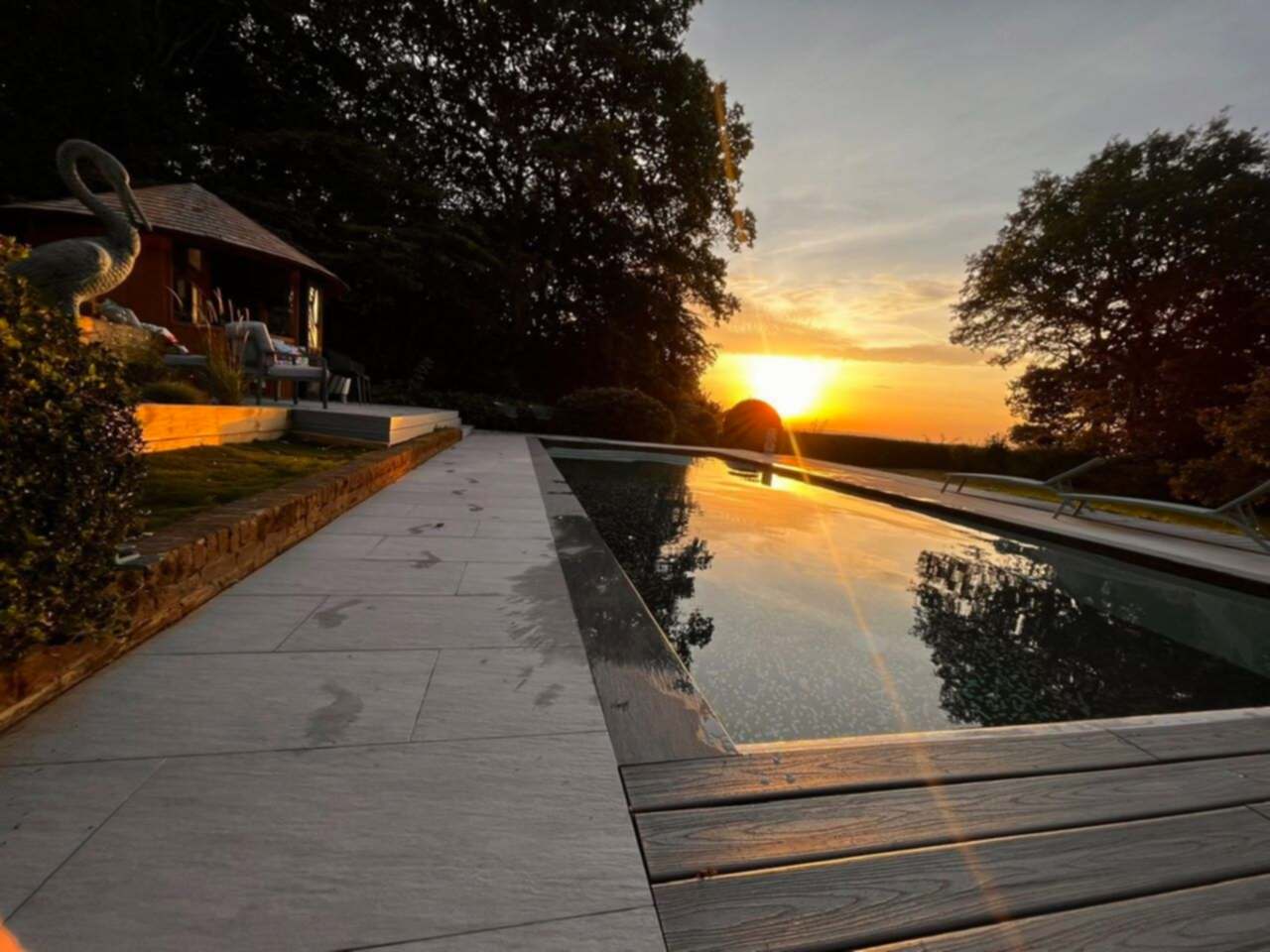 A stunning sunset photo of the refurbished swimming pool and patio