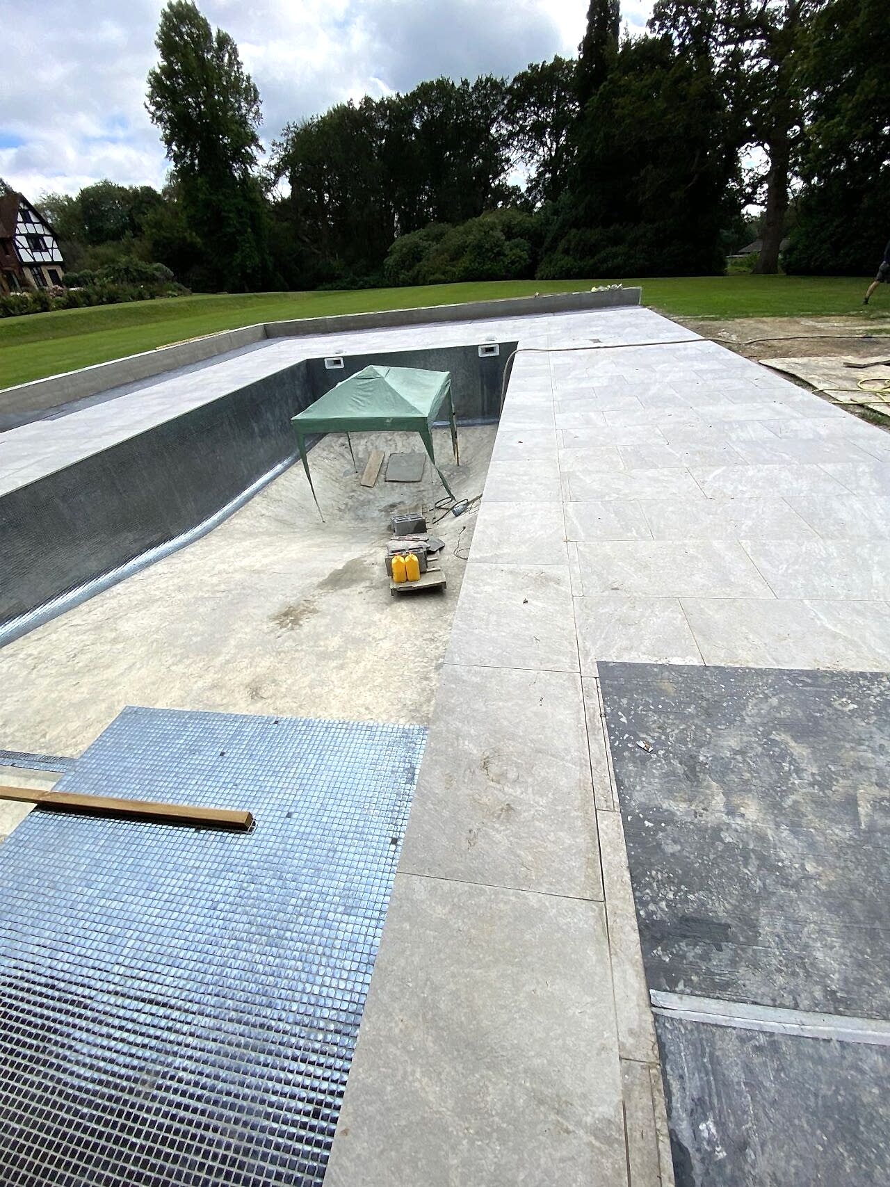 The tiling of the swimming pool continues down from the steps