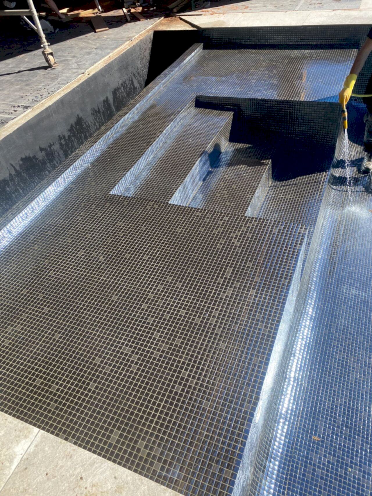 After the tiling is ready, the UKSP team is cleaning off any dirt from the new mosaic tiles