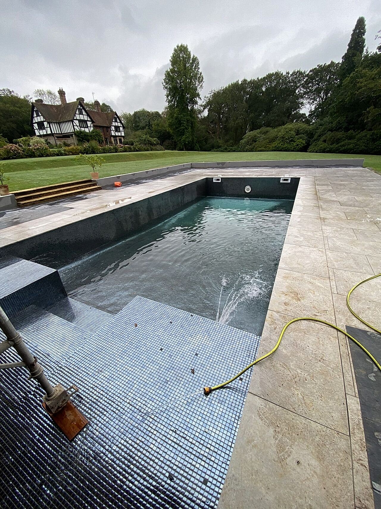 The newly tiled pool is being filled with water for the first time