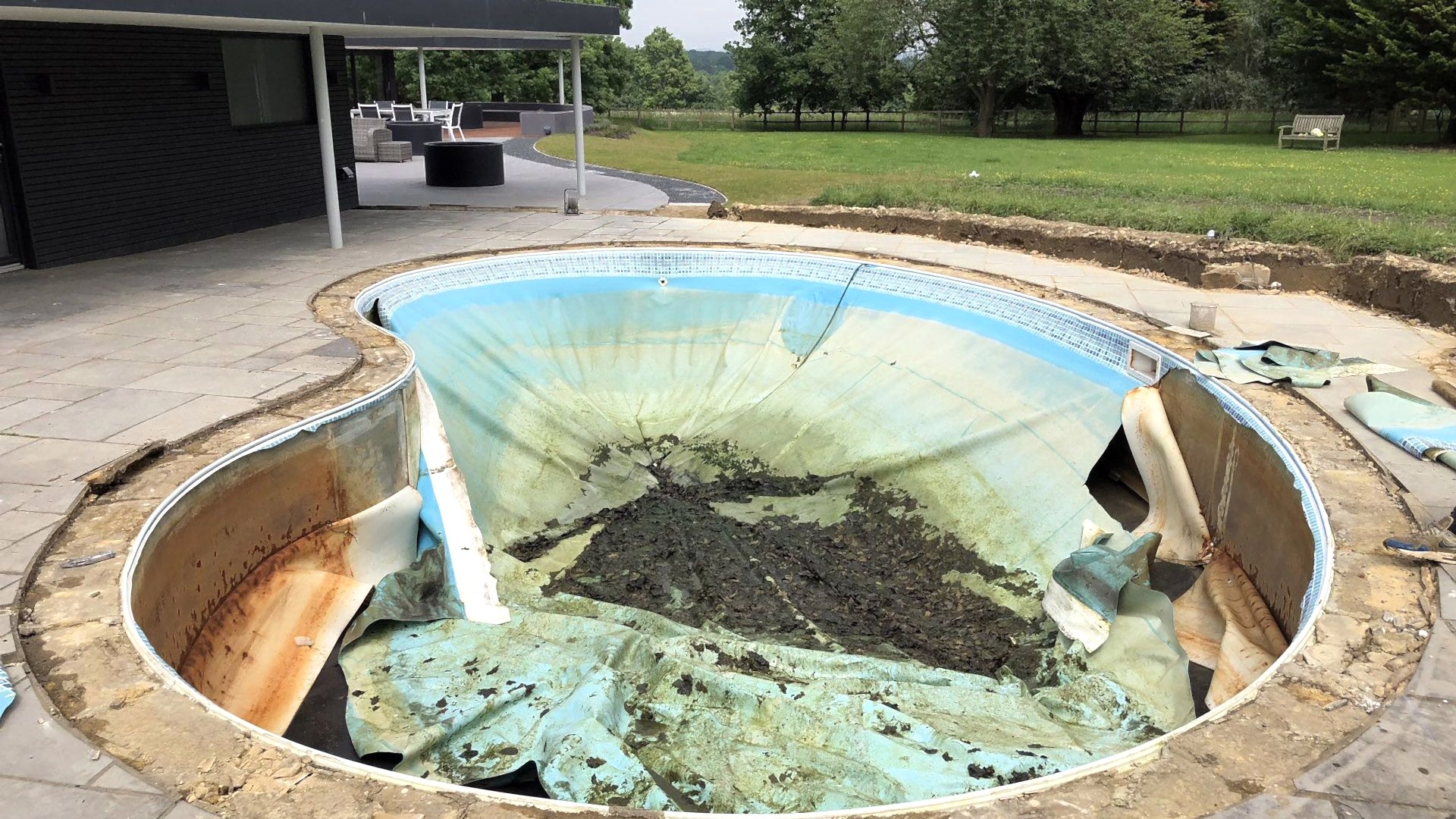 Damaged outdoor kidney shaped swimming pool