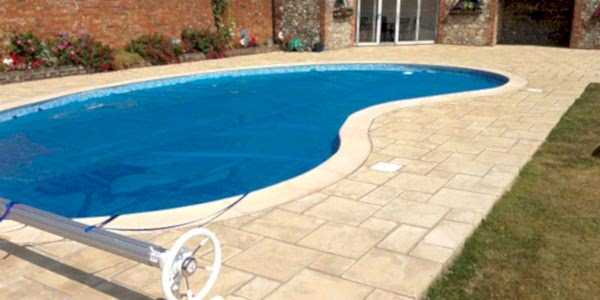 Manual Swimming Pool Cover over a kidney shaped concrete swimming pool