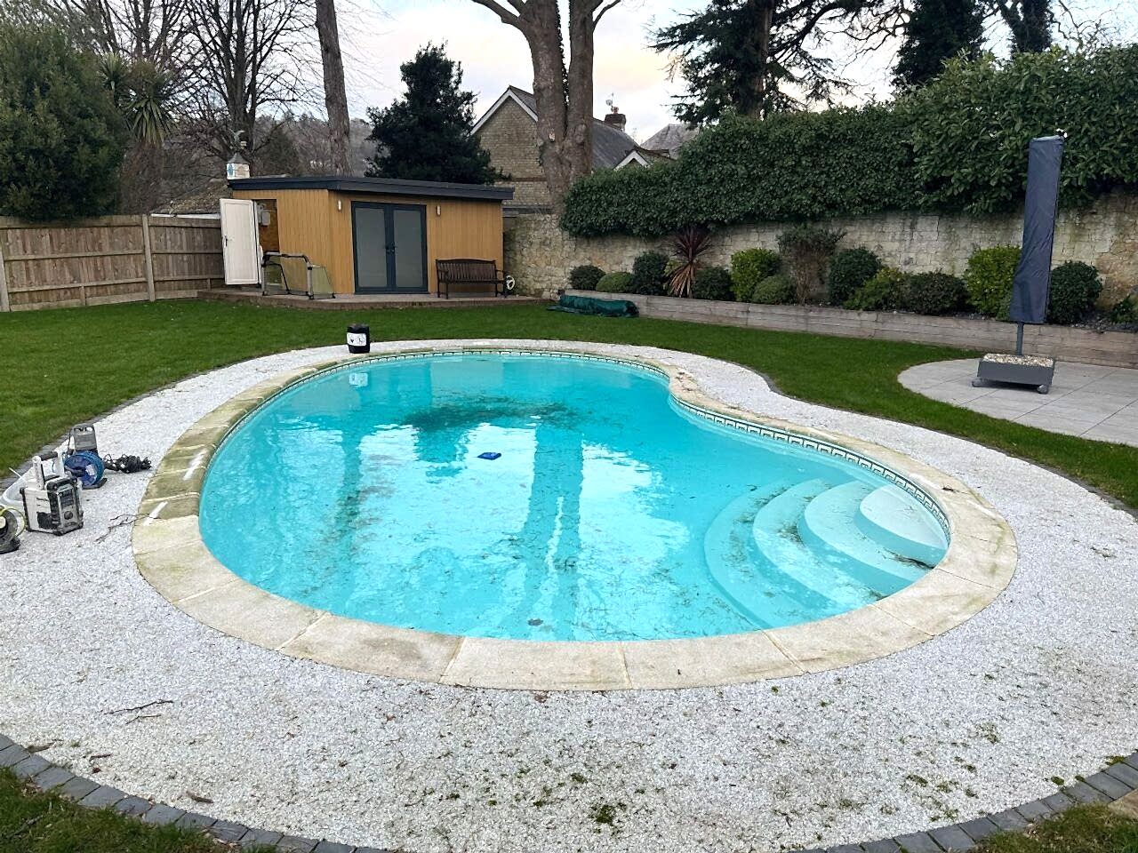 The original swimming pool before the upgrades including an automatic safety cover and full glass mosaic tile interior