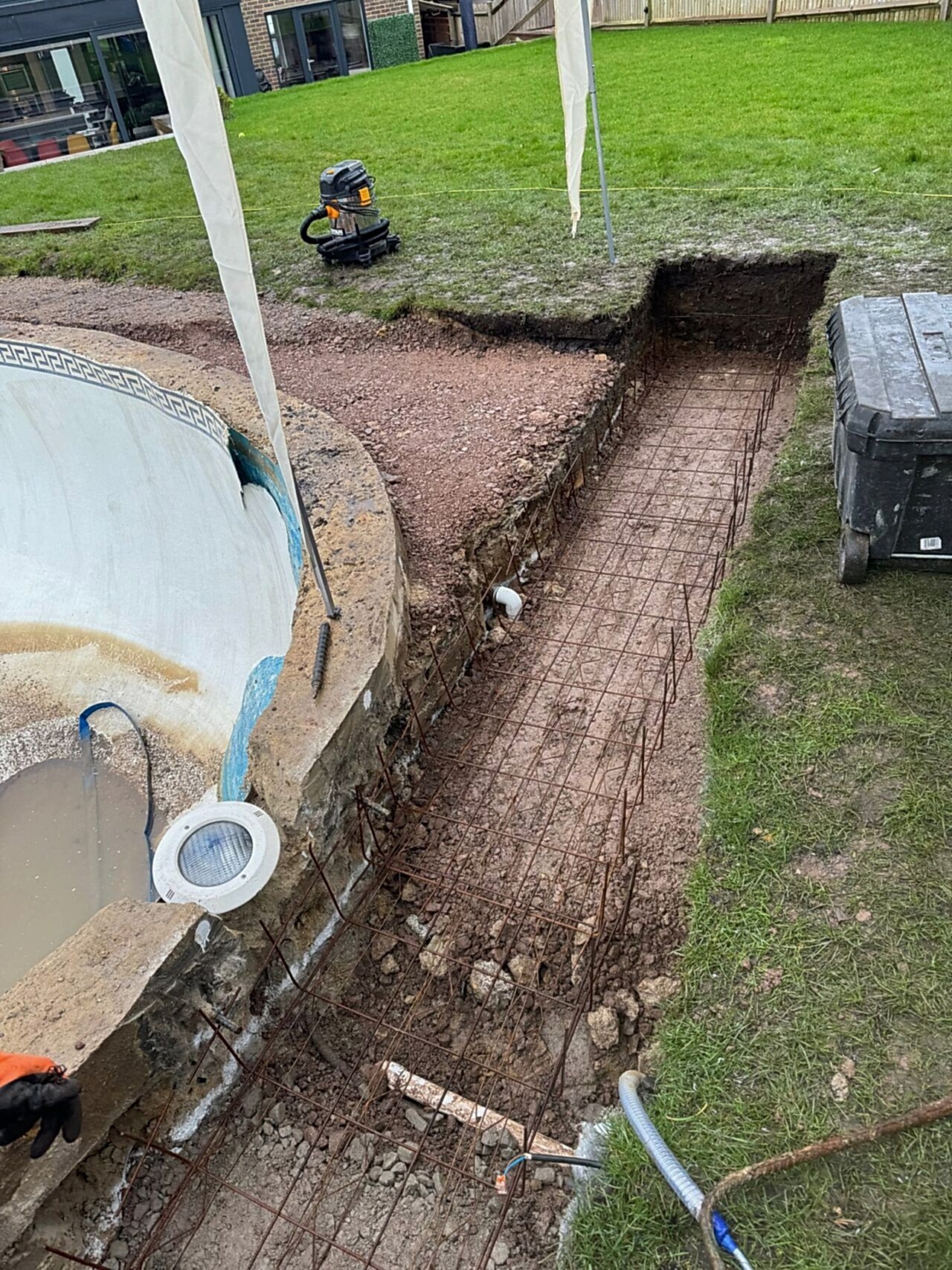 Metal wireframe being installed to strengthen the edge of the swimming pool