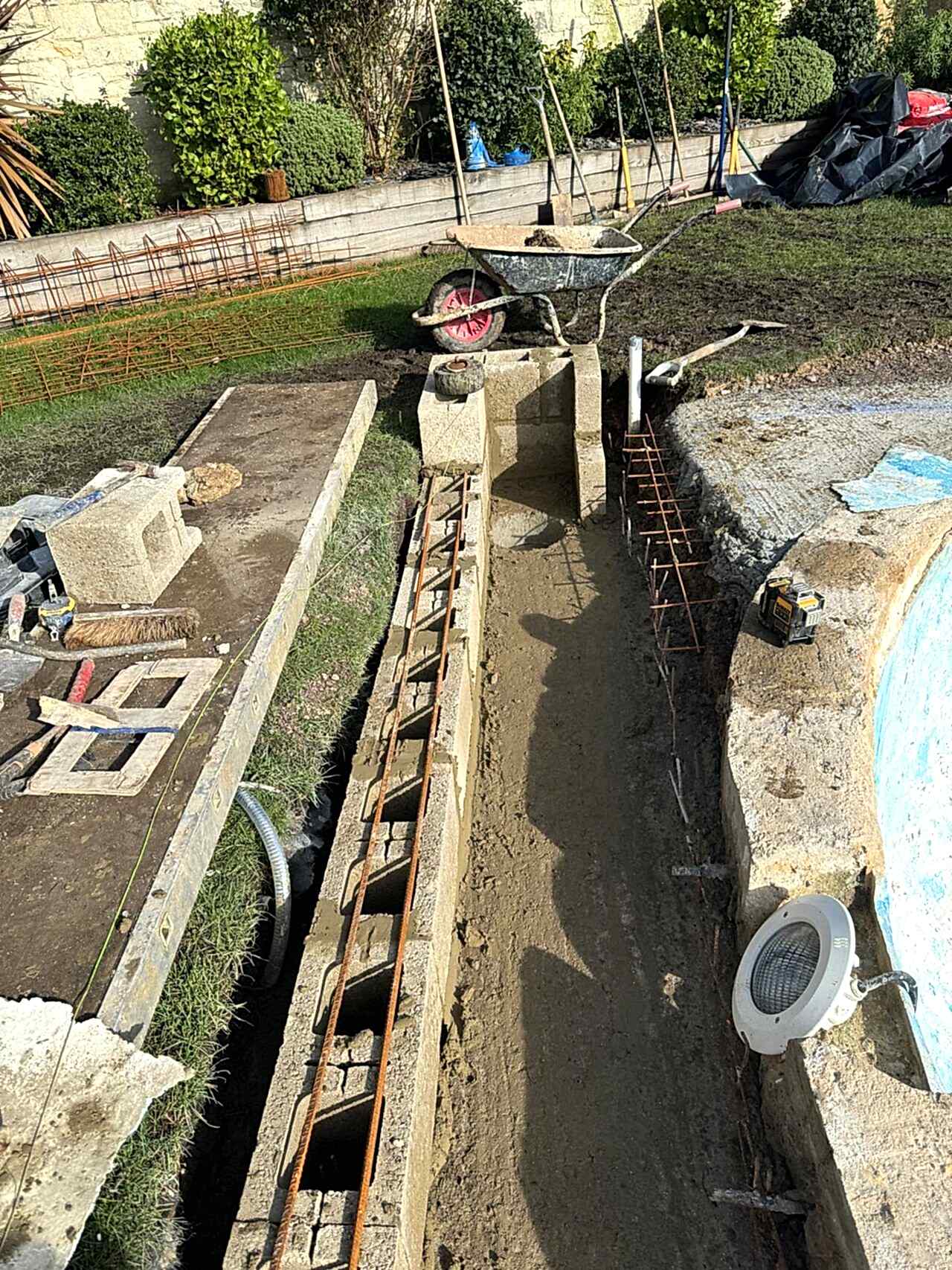 Cement blocks being installed with the wireframe to strengthen the edge of the swimming pool