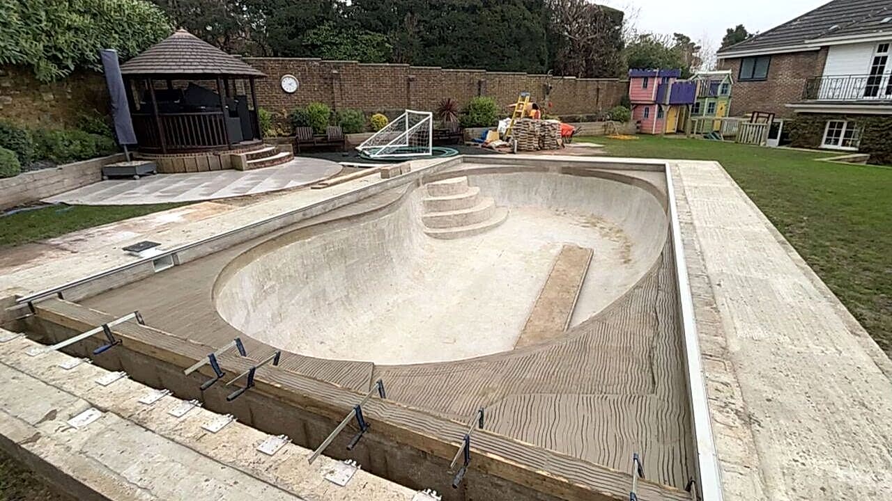 Wooden beam being fixed at the short edge of the swimming pool.