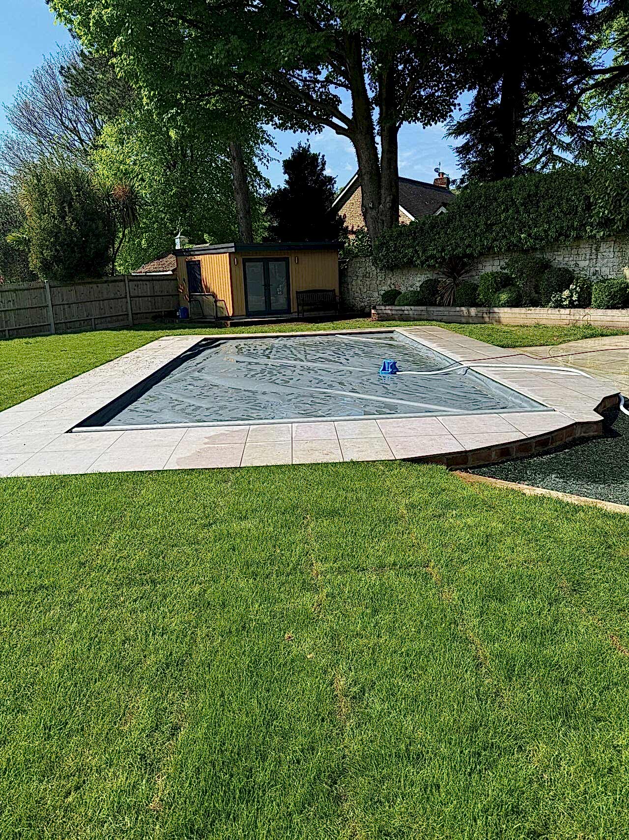 Finished shot of the remodelled of the swimming pool with pool house in the background
